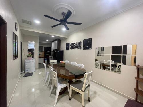 a dining room with a table and a ceiling fan at 3Bedroom Full AirCond House with Pool@PortDickson in Port Dickson