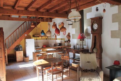une cuisine avec une table et une horloge au mur dans l'établissement logement au sein d une abbaye cistercienne, à Saint-Martin-le-Vieil