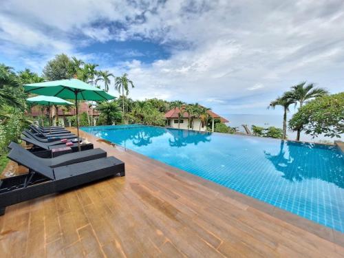 uma piscina num resort com cadeiras e um guarda-sol em Seabreeze @ Koh Mak em Ko Mak