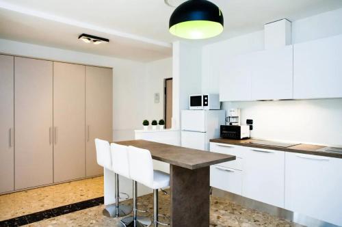 a kitchen with a wooden table and white cabinets at Residence Degli Aranci - by Casêta in Ancona