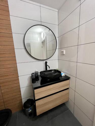 a bathroom with a black sink and a mirror at דירת אירוח מפנקת בעיר אשקלון - 5 דקות נסיעה מהים in Ashqelon