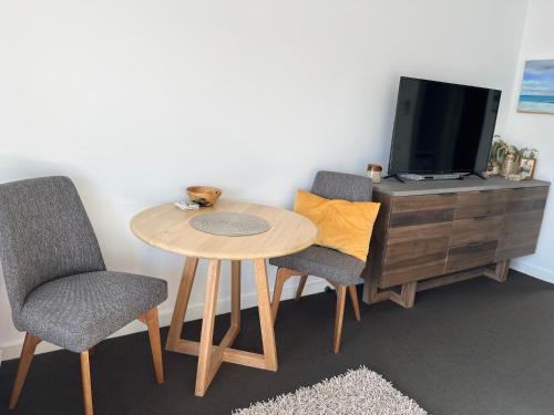 a room with a table and two chairs and a tv at Lorne World in Lorne