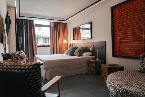 ラスパルマス・デ・グランカナリアにあるPoem Suites, Las Canterasのベッドとソファ付きのホテルルーム