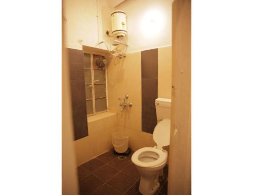 a small bathroom with a toilet and a shower at HOTEL SANDS INN, Jodhpur in Jodhpur