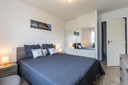 ein Schlafzimmer mit einem großen Bett und einem Spiegel in der Unterkunft Bassin d'arcachon in Arès