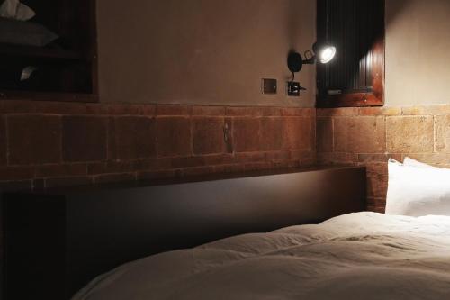 a bed in a room with a brick wall at 序室 Narrative in Jinhu