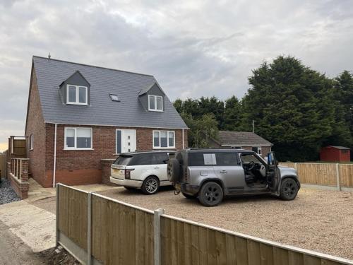 two cars parked in a driveway in front of a house at 4 bedroom House Boston Lincs Pet & Child friendly in Boston