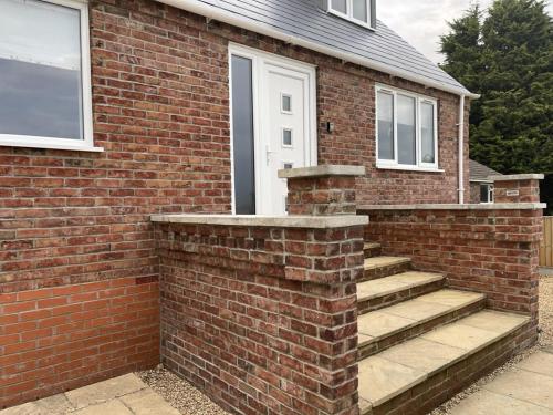 a brick house with stairs leading to a door at 4 bedroom House Boston Lincs Pet & Child friendly in Boston
