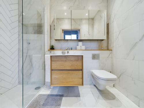 uma casa de banho com um WC, um lavatório e um chuveiro em Luxury Unique 2bedroom city centre em Manchester