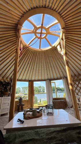 a room with a large window in a yurt at Mongoolse yurt met uitzicht op fort nigtevecht in Nigtevecht