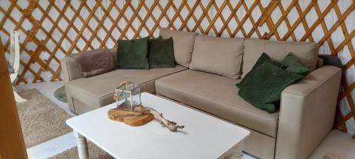 a living room with a couch and a table at Mongoolse yurt met uitzicht op fort nigtevecht in Nigtevecht