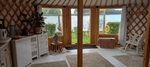 a kitchen with a room with a view of the water at Mongoolse yurt met uitzicht op fort nigtevecht in Nigtevecht