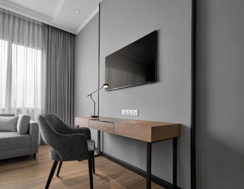a room with a desk with a chair and a tv at AC Hotel by Marriott Penang in Bayan Lepas