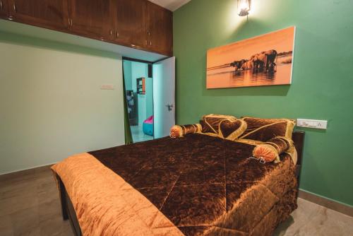 a bedroom with a bed in a room with green walls at Cheerful 2-bedroom near Auro Beach in Kālapettai