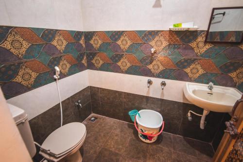 a bathroom with a toilet and a sink at Cheerful 2-bedroom near Auro Beach in Kālapettai