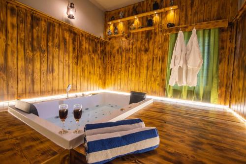 a bathroom with a tub with two glasses of wine at Cheerful 2-bedroom near Auro Beach in Kālapettai