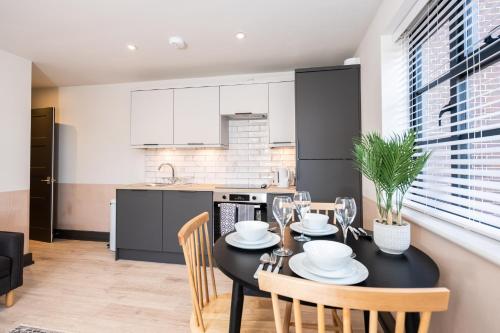 a kitchen and dining room with a black table and chairs at 2 Castle Mews in Salisbury