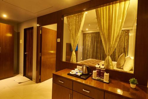 a bathroom with a vanity with a large mirror at Hotel G-Square - Shirdi in Shirdi