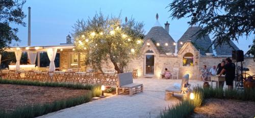 a house with a patio with chairs and lights at La Relais del Trullo in Putignano