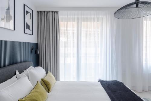 1 dormitorio con cama blanca y ventana grande en Blue Jeans White Shirt - Fitzrovia - by Frankie Says, en Londres
