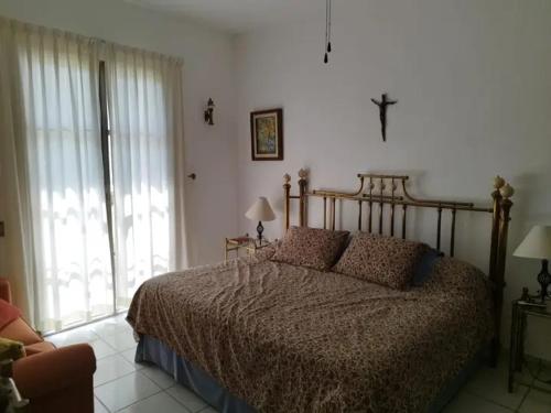 um quarto com uma cama e uma cruz na parede em Renta de cuartos por dia em Ameca