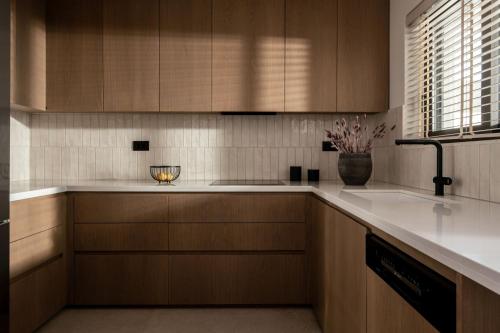 a kitchen with wooden cabinets and a sink at Eran Luxury Villa with Private Pool & Sea Views, by ZanteWize in Akrotiri