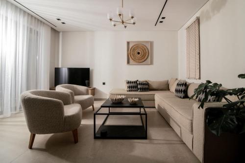 a living room with a couch and chairs and a tv at Eran Luxury Villa with Private Pool & Sea Views, by ZanteWize in Akrotiri