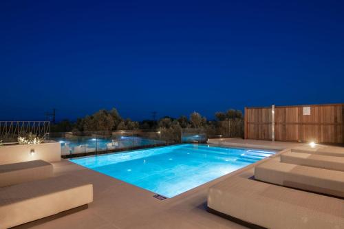 a swimming pool at night with chairs and lights at Eran Luxury Villa with Private Pool & Sea Views, by ZanteWize in Akrotiri