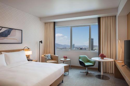 a hotel room with a bed and a large window at Doubletree By Hilton Fujairah City in Fujairah