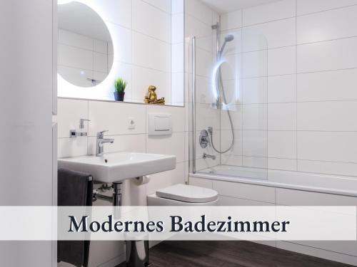 ein Bad mit einem Waschbecken, einem WC und einer Dusche in der Unterkunft Relax Apartment Black & White in Friedrichshafen
