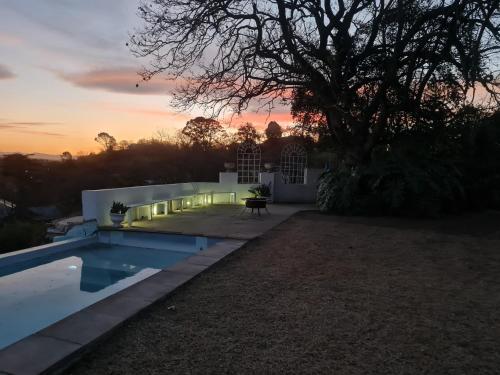 a backyard with a swimming pool and a tree at Bonnie Highlands in Ladysmith