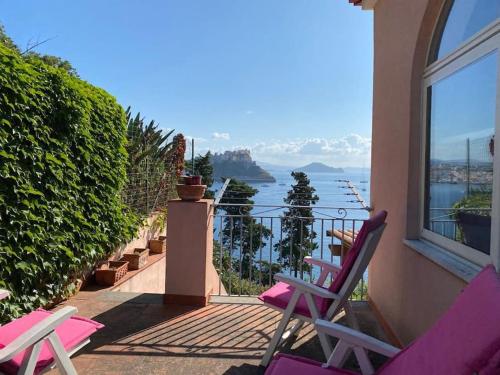- deux chaises sur un balcon avec vue sur l'eau dans l'établissement Villetta panoramica sul mare, à Procida