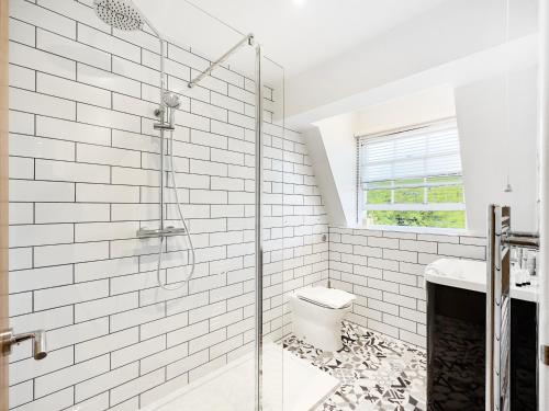 a white bathroom with a shower and a toilet at Serene 2BR Retreat in Bishop's Stortford in Bishops Stortford