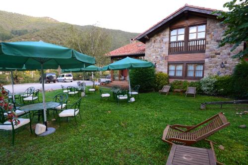 a yard with chairs and tables and umbrellas at Hotel-Posada La Casa de Frama in Frama