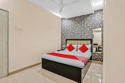 a bedroom with a bed with red pillows at OYO Flagship Hotel Smbha Palace in Mumbai