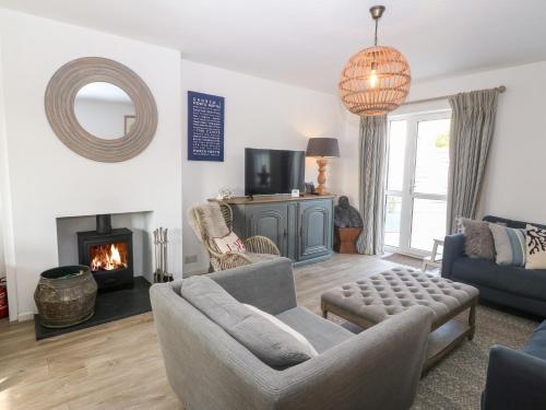 a living room with a couch and a fireplace at Llwyn Onn in Pwllheli