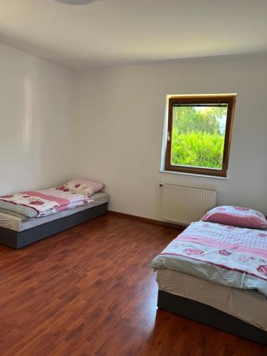 2 camas en una habitación con ventana en Appartments, en Gerasdorf bei Wien