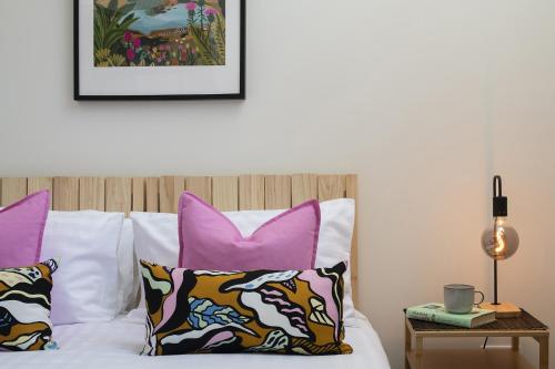 a bedroom with pink and purple pillows on a bed at Apartment 1 Y Capel, Free on site parking, Central to town and a55 expressway in St Asaph