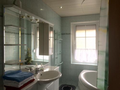 ein Badezimmer mit einem Waschbecken, einer Badewanne und einem Waschbecken in der Unterkunft Ferienwohnung Thale in Thale