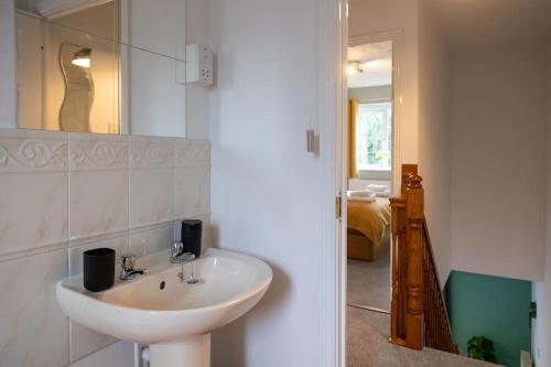 a bathroom with a sink and a mirror at Woodpecker House By RentMyHouse in Hereford