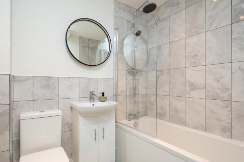 a bathroom with a toilet and a sink and a mirror at Apartment 1 Y Capel, Free on site parking, Central to town and a55 expressway in St Asaph