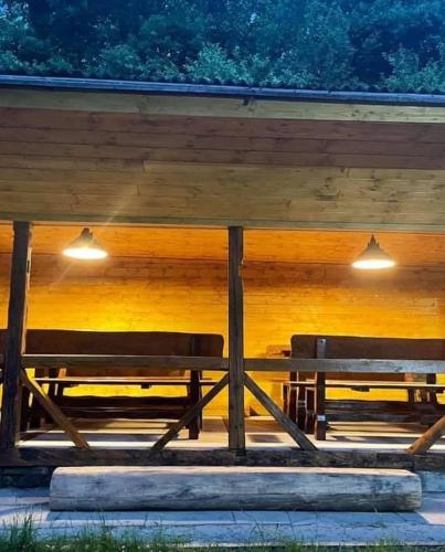 two benches sitting under a wooden structure with lights at Chata Vápenná in Jeseník