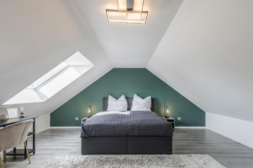 ein Schlafzimmer mit einem Bett mit einer grünen Wand in der Unterkunft Luxus Wohnung I Gasgrill I Smart-TV I Balkon in Gütersloh