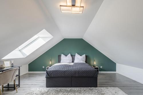 a bedroom with a bed with a green wall at GT-City Suite 01 I Gasgrill I Smart-TV I Balkon in Gütersloh