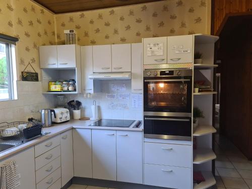 a kitchen with white cabinets and an oven at WOODY Pt - AMAZING 1970's SHARE HOUSE BY THE SEA-4 rooms available! in Woody Point
