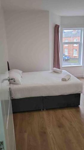 a large bed in a room with a window at Catherine 5 bedroom house in Crewe