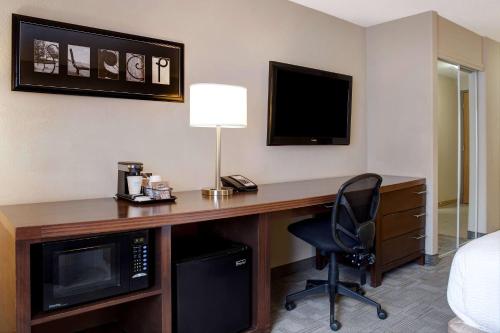 a hotel room with a desk with a television and a chair at Days Inn by Wyndham Medicine Hat in Medicine Hat