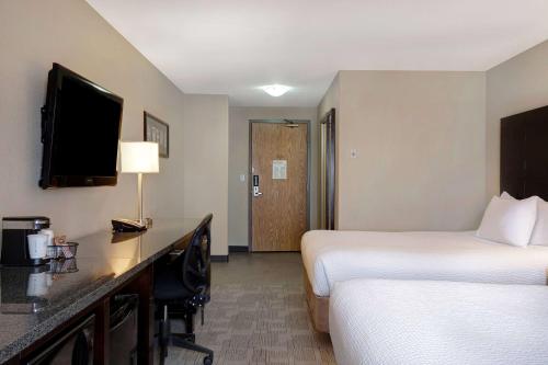 a hotel room with two beds and a desk at Days Inn by Wyndham Medicine Hat in Medicine Hat