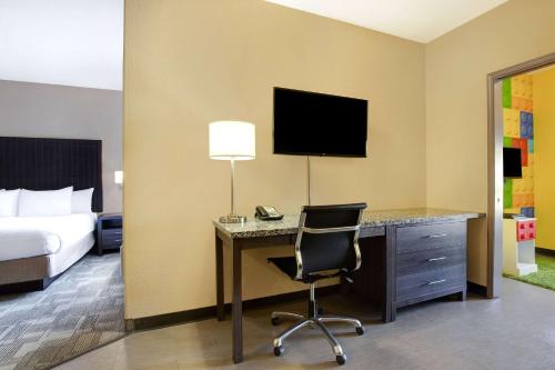 a hotel room with a bed and a desk with a computer at Days Inn by Wyndham Medicine Hat in Medicine Hat