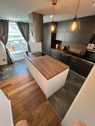 a kitchen with black cabinets and a wooden counter top at Apartment Bacci in Vrhnika